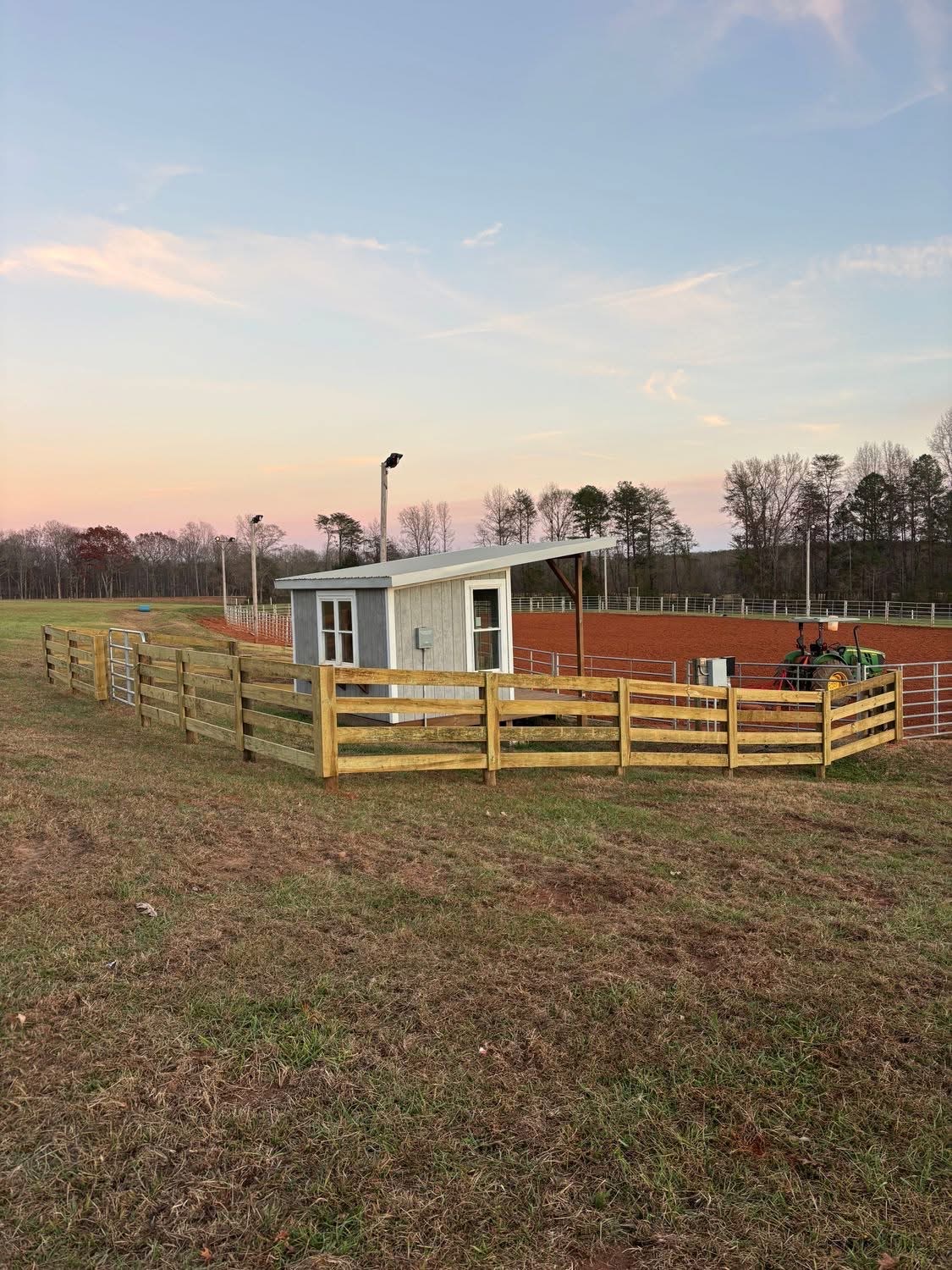 Ranch fence around arena at sunset