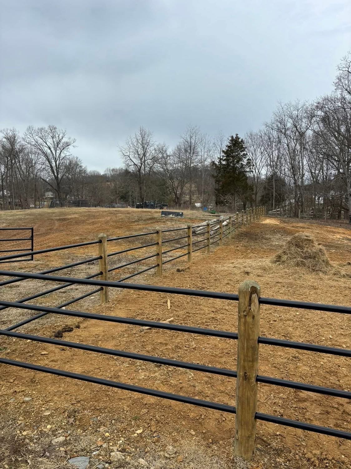Black pipe metal fencing with wood posts